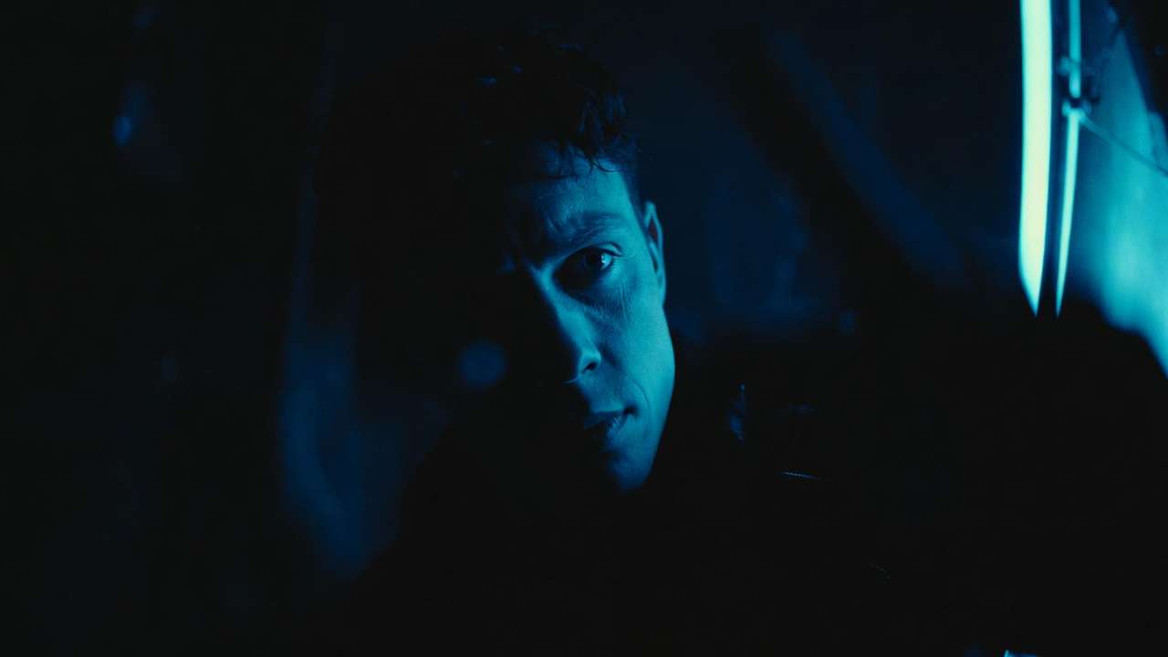 Close-up of man, intense blue light from right