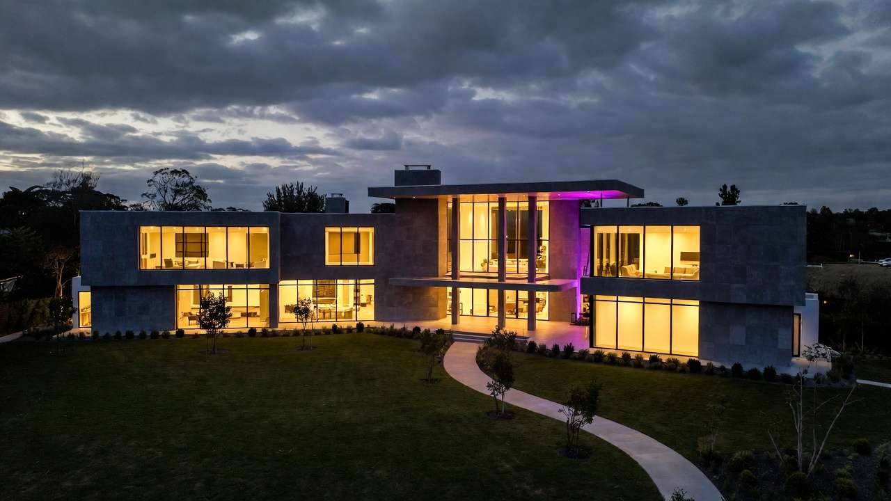 Modern villa at night, glass walls, purple accent room